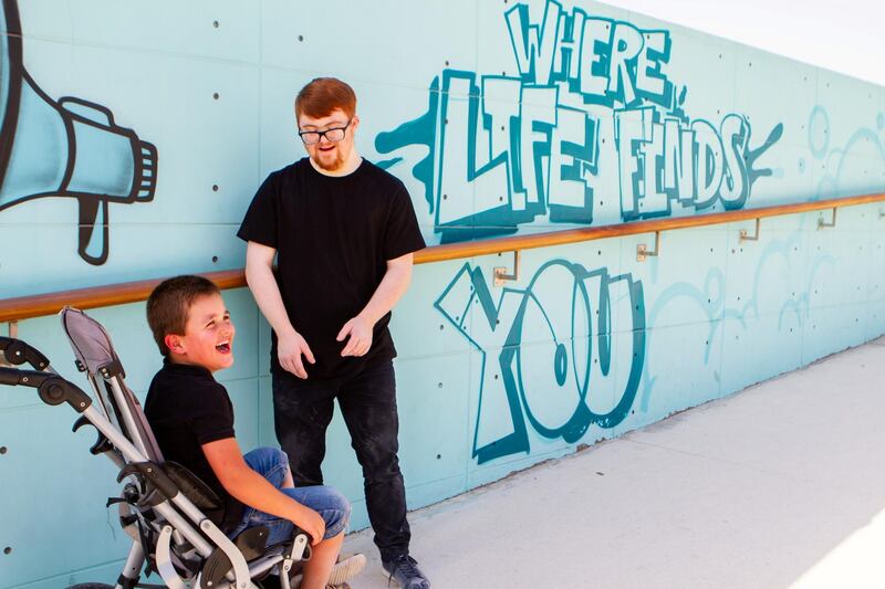 Kieran laughs with Sam. People with disabilities are exempt from wearing masks. Courtesy: Em Ray