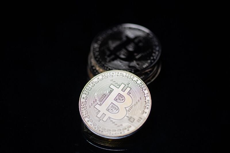 This photograph taken on April 26, 2021 in Paris shows a physical imitation of the Bitcoin crypto currency. / AFP / Martin BUREAU
