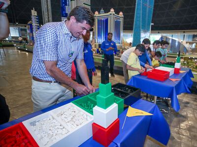 Children from Sanad Village compete with  Scott O’Neil, chief executive of Merlin Entertainments, at Legoland Dubai to build a LEGO Burj Khalifa. Victor Besa / The National