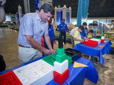 Children from Sanad Village compete with  Scott O’Neil, chief executive of Merlin Entertainments, at Legoland Dubai to build a LEGO Burj Khalifa. Victor Besa / The National