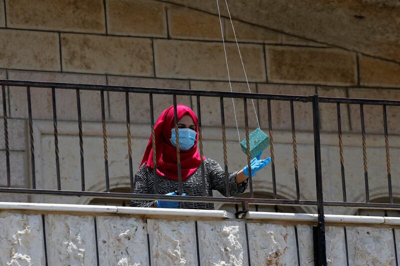 A Palestinian woman who is infected with coronavirus disease receives vitamins delivered by a drone in Beit Ummar in the Israeli-occupied West Bank. Reuters