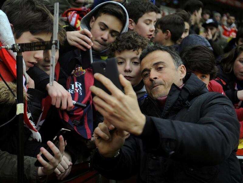 Barcelona’s coach Luis Enrique takes selfies with fans before match. REUTERS/Eloy Alonso