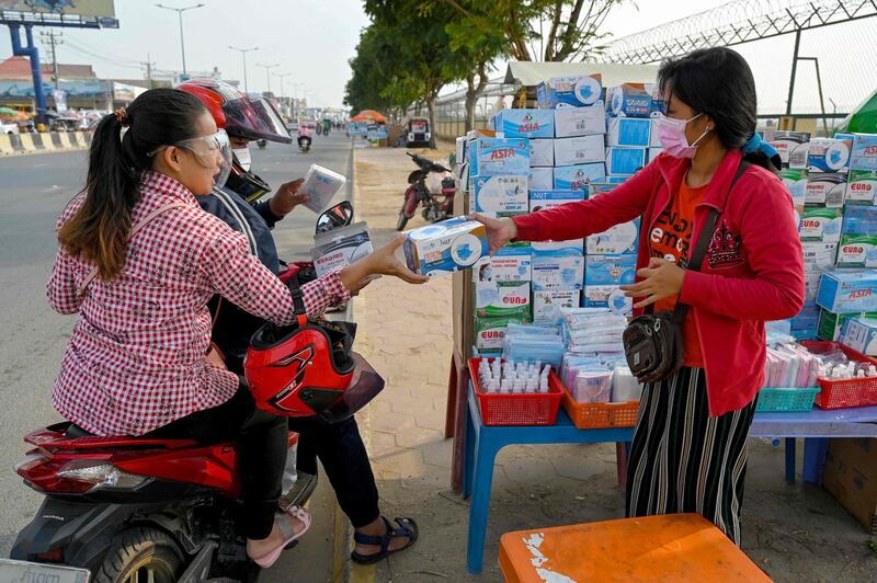 Motorists buy a box of face masks from a vendor along a street in Phnom Penh, Cambodia. AFP