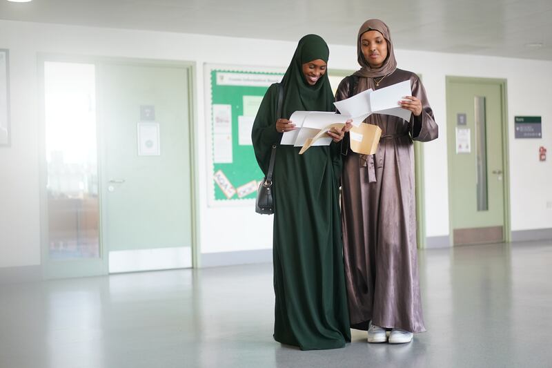 Nagma Abdi (left) and Zuhoor Haibe with their A-level results at Ark Putney Academy, in London, on August 18. PA Wire