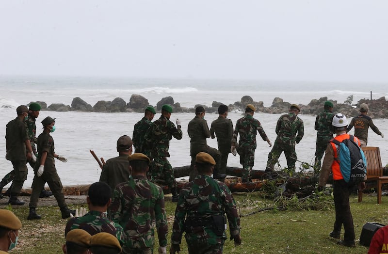 Indonesian soldiers and rescue teams search the bodies of victims at a beach resort in Tanjung Lesung. AP