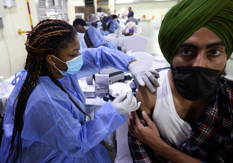 A healthcare worker gives an injection of coronavirus vaccine to a Sikh resident at the Guru Nanak Darbar gurudwara (Sikh temple), in Dubai. Karim Sahib / AFP
