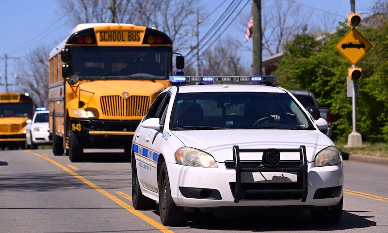 Metro Nashville Police cars escort the school buses to the church where pupils will be reunited with their parents. AP