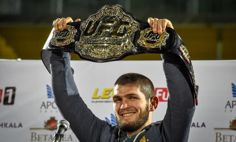 UFC lightweight champion Khabib Nurmagomedov of Russia raises his champions belt upon the arrival in Makhachkala on October 8, 2018. Nurmagomedov defeated Conor McGregor of Ireland in their UFC lightweight championship bout by way of submission during the UFC 229 event inside T-Mobile Arena on October 6, 2018 in Las Vegas, Nevada. / AFP / Vasily MAXIMOV 
