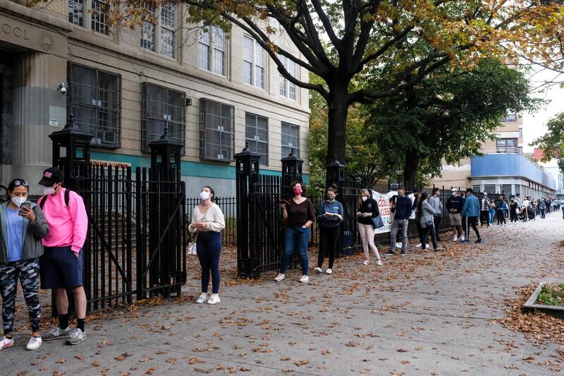 epa08771052 Voters wait in line to vote early in the US presidential elections in a Community Center in Brooklyn, New York, USA, 23 October 2020. US President Donald J. Trump will face Democratic candidate Joe Biden in the US elections on 03 November.  EPA/Alba Vigaray