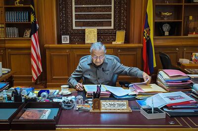 In this photo released by Prime Minister Office, Malaysian Prime Minister Mahathir Mohamad works at his office in Putrajaya, Malaysia, Tuesday, Feb. 25, 2020. Malaysia's king accepted Mahathir's shocking resignation Monday. The move came in tandem with plans by Mahathir's supporters to team up with opposition parties to form a new government and foil the transition of power to his named successor, Anwar Ibrahim. (Prime Minister Office via AP)