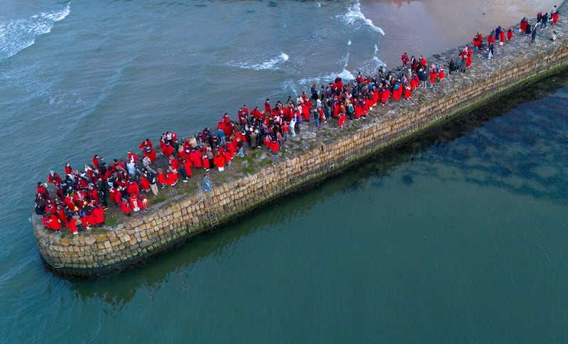 Students from the University of St Andrews in Scotland, wearing their traditional red gowns, take part in The Gaudie, a procession through the town and down to the pier. PA