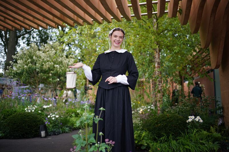 A woman dressed as Florence Nightingale poses in the garden of the same name. PA