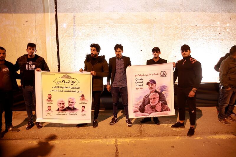 Popular Mobilisation Forces and their supporters hold posters of Abu Mahdi Al Muhandis and Qassem Suleimani at Baghdad's international airport. AP Photo