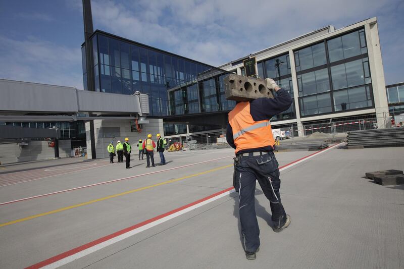 BERLIN, GERMANY - MARCH 20:  A worker walks on the tarmac at Willy Brandt Berlin Brandenburg International Airport on March 20, 2012 in Berlin, Germany. The new airport, which will replace the city's current Tegel and Schoenefeld airports, will officially open in May and begin operaiton on June 3.  (Photo by Sean Gallup/Getty Images)