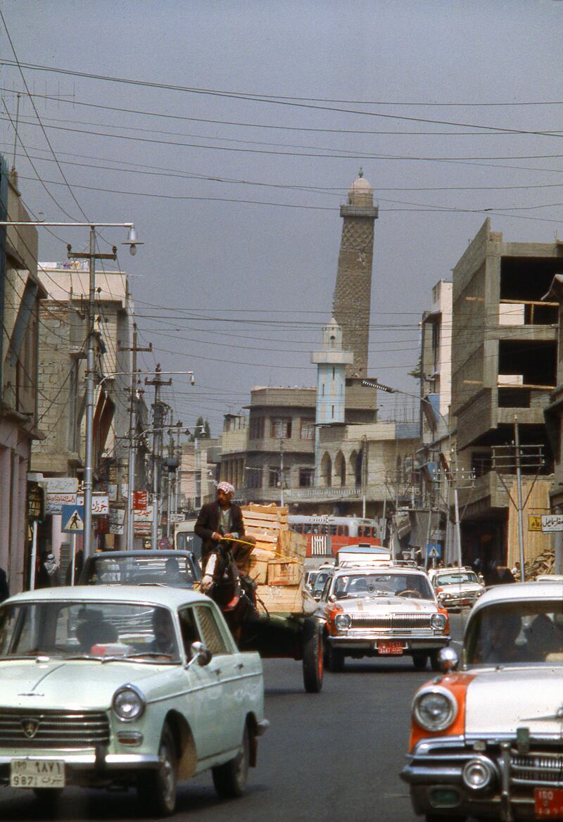 MOSUL - JANUARY 1 1978; Heavy traffic on street in downtown Mosul, largest city in Northern Iraq, with Leaning Minaret of the Great Mosque in the background, circa 1978 (Nik Wheeler/Corbis via Getty Images)