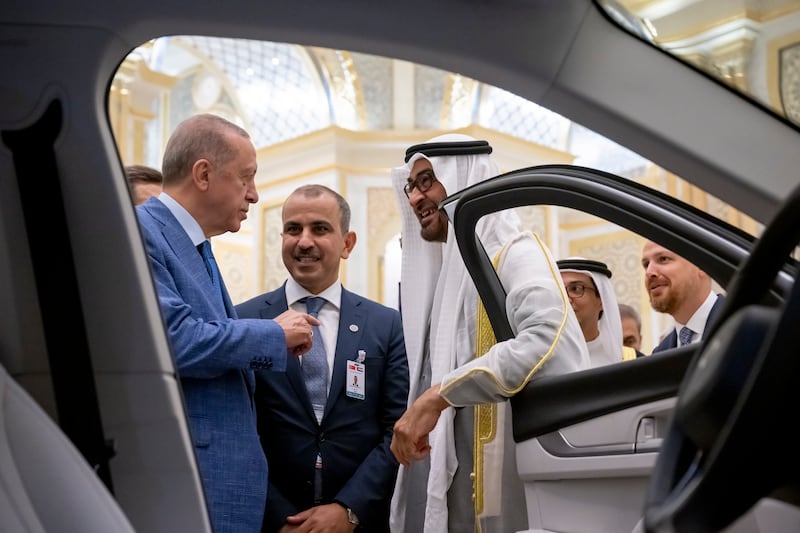 Mr Erdogan shows Sheikh Mohamed a Turkish-made Togg electric car at Qasr Al Watan. Photo: UAE Presidential Court