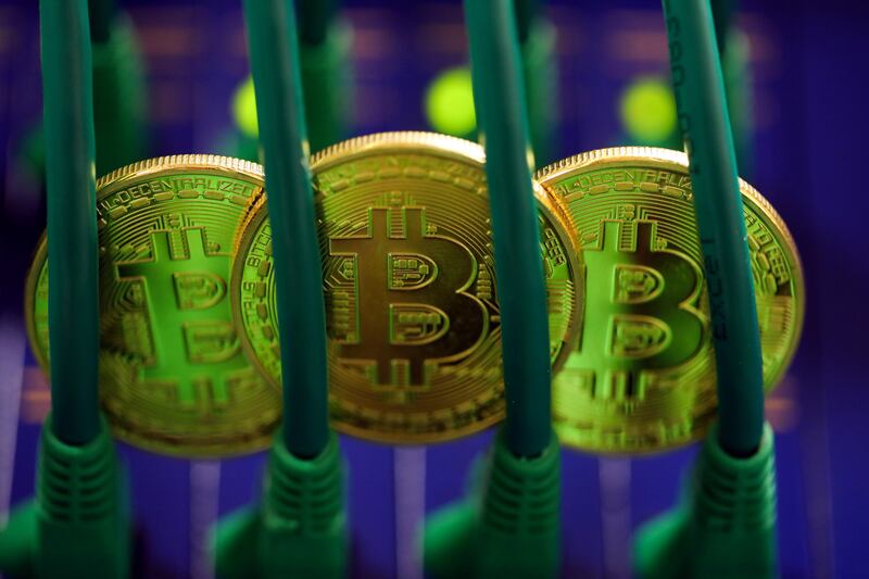 Bitcoins sit among Ethernet cables inside a communications room at an office in this arranged photograph in London, U.K., on Tuesday, Sept. 5, 2017. Bitcoin steadied after its biggest drop since June as investors and speculators reappraised the outlook for initial coin offerings. Photographer: Chris Ratcliffe/Bloomberg