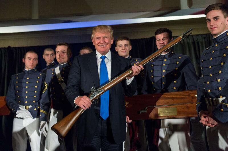 CHARLESTON, SC - FEBRUARY 22: Reality TV host and New York real estate mogul Donald Trump holds up a replica flintlock rifle awarded him by cadets during the Republican Society Patriot Dinner at the Citadel Military College on February 22, 2015 in Charleston, South Carolina. Trump and U.S. Sen. Tim Scott (R-SC) were honored at the annual event.   Richard Ellis/Getty Images/AFP