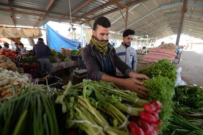 An Iraqi vendor sells vegetables at a local market. Iraq’s domestic stability has improved since the new government took office in October 2022. EPA