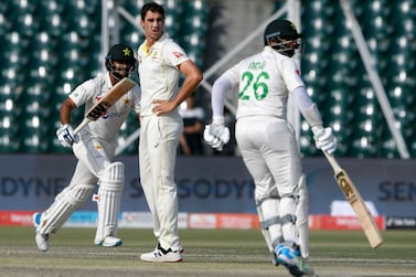 Pakistan's Abdullah Shafique (L) and Imam-ul-Haq (R) run between the wickets as Australia's captain Pat Cummins watches during the fourth day of the third and final Test cricket match between Pakistan and Australia at the Gaddafi Cricket Stadium in Lahore on March 24, 2022.  (Photo by Aamir QURESHI  /  AFP)