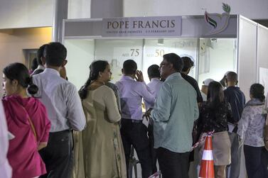 People queue to collect tickets for the Papal Mass and to buy Pope merchandise at St Mary's Catholic Church on Monday. Leslie Pableo for The National