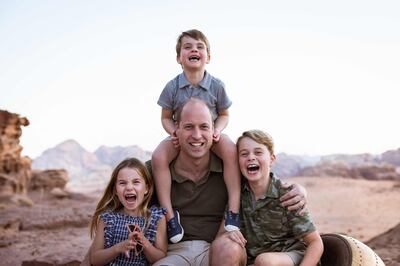 Prince William poses for a photograph with his children, released to mark Father's Day. AFP