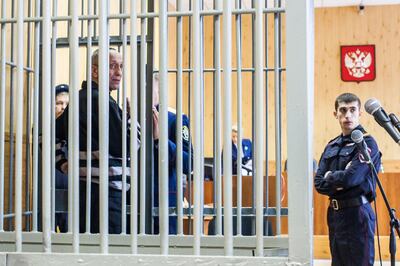 Mikhail Popkov stands inside a defendants' cage during a court hearing in Irkutsk on December 10, 2018. A Siberian policeman who raped and killed women after offering them late-night rides was found guilty of dozens more murders on December 10, 2018, making him Russia's most prolific serial killer of recent times. A court in the city of Irkutsk found Mikhail Popkov guilty of 56 murders between 1992 and 2007, sentencing him to a second life term. He was already in prison after being convicted of killing 22 women in 2015. / AFP / Anton KLIMOV
