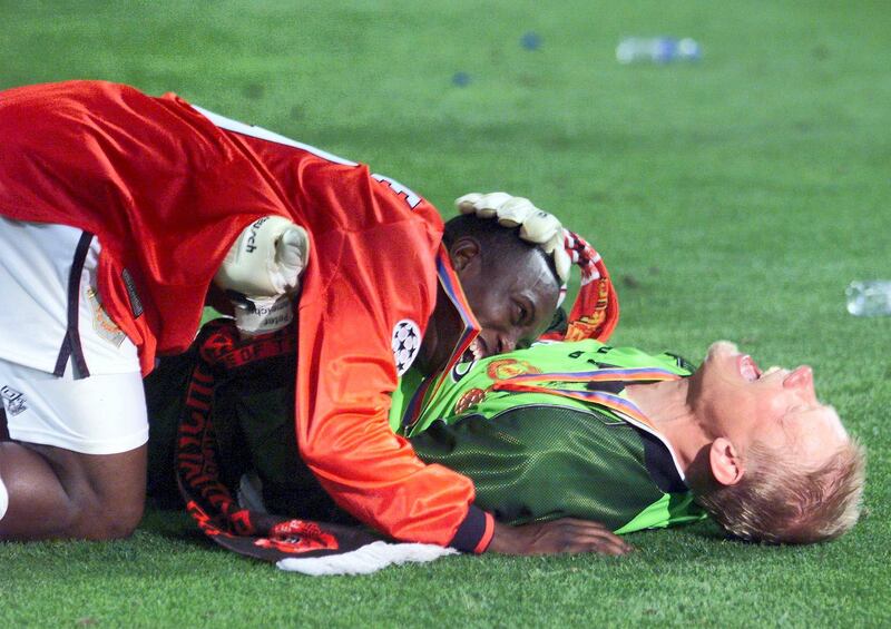 Goalkeeper Peter Schmeichel (on the ground/r) and forward Dwight Yorke of Manchester United jubilate after winning the final of the soccer Champions League against Bayern Munich, 26 May 1999 at the Camp Nou Stadium in Barcelona. Manchester United won 2-1.
(ELECTRONIC IMAGE) (Photo by ERIC CABANIS / AFP)
