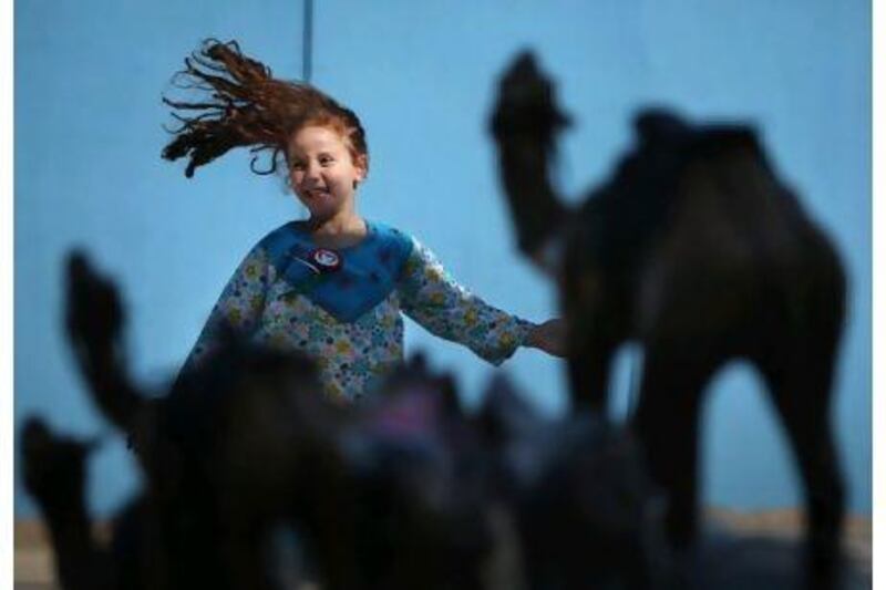 Grade one student Lara Elbilly, 6, runs through the courtyard of GEMS World Academy during one of its National Day events.