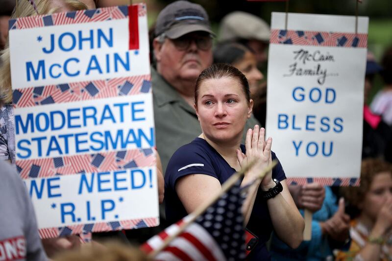 People stand in silence during a wreath laying ceremony to honour the late Senator John McCain. Getty Images / AFP