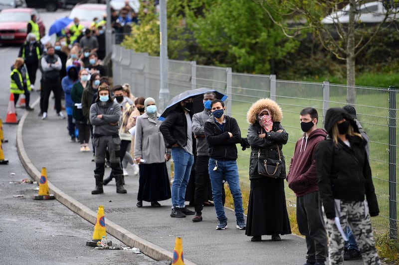Members of the public queue to receive a Covid-19 vaccine at a temporary vaccination centre at the Essa academy in Bolton, northwest England on May 17, 2021.  / AFP / Oli SCARFF
