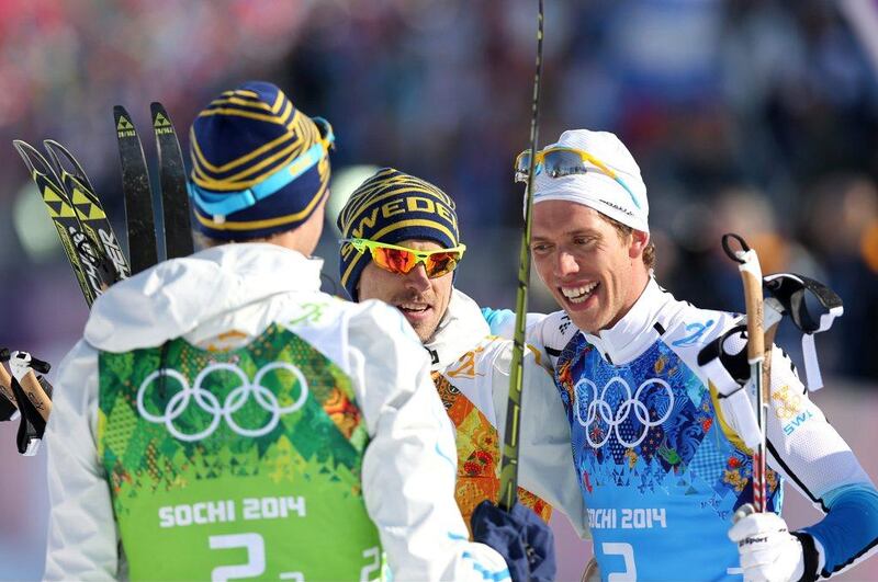 Sweden's cross-country gold medalists Marcus Hellner, right, Johan Olsson, centre, and Daniel Richardsson, left, celebrate after crossing the finish line after the men's 4 X 10 km relay on Sunday. Armando Babani / EPA 