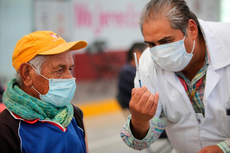 A nurse shows an elderly man a syringe prepared with dose of the Sinovac COVID-19 vaccine, before he is inoculated at the Americas Cultural Center, in Ecatepec, Mexico. AP Photo