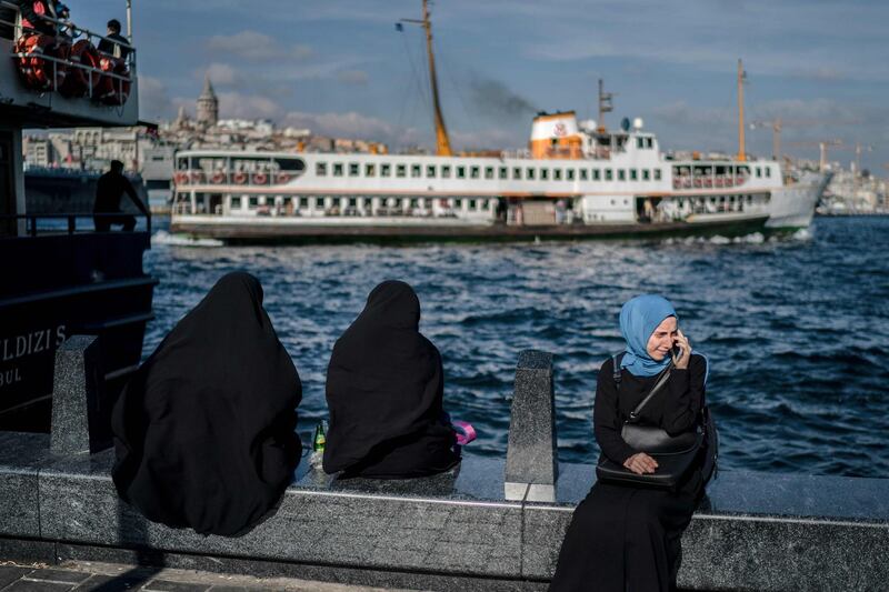 Veiled women sit on a banks of the Bosphorus river at the Eminonu district of Istanbul. AFP