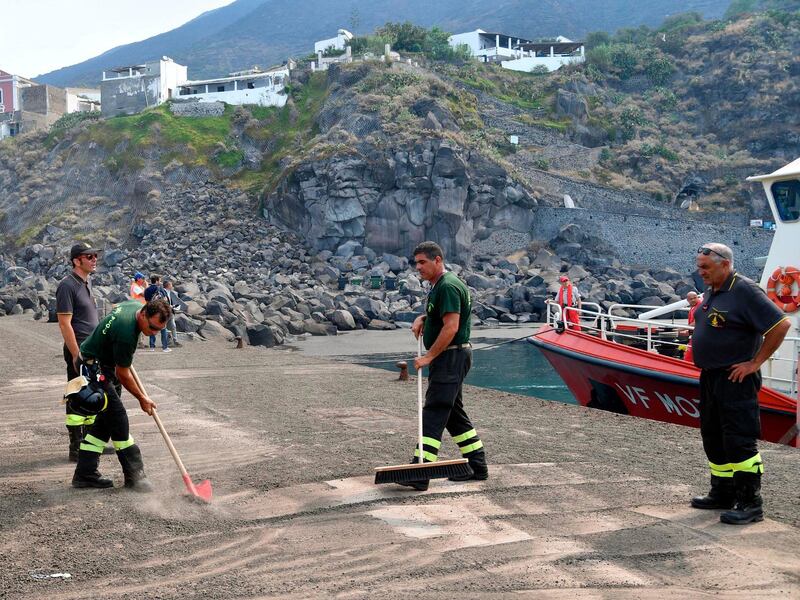Firefighters sweep up ash in the village of Ginostra, on the small Sicilian island of Stromboli, southern Italy, a day after the Stromboli volcano erupted. Civil protection authorities said a hiker was killed during the eruptionswhich sent about 30 tourists jumping into the sea for safety. AP