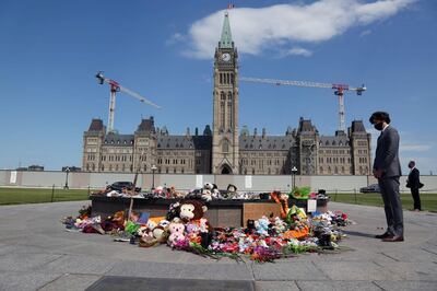 Canadian Prime Minister Justin Trudeau visits the makeshift memorial erected in honor of the 215 indigenous children remains found at a boarding school in British Columbia, on Parliament Hill June 1, 2021 in Ottawa.   Trudeau, who has made reconciliation with Canada's nearly 1.7 million indigenous people a priority of his government since coming to power in 2015, said he would speak with his ministers to shore up "next and further things we need to do to support (residential school) survivors and the community." / AFP / Dave Chan
