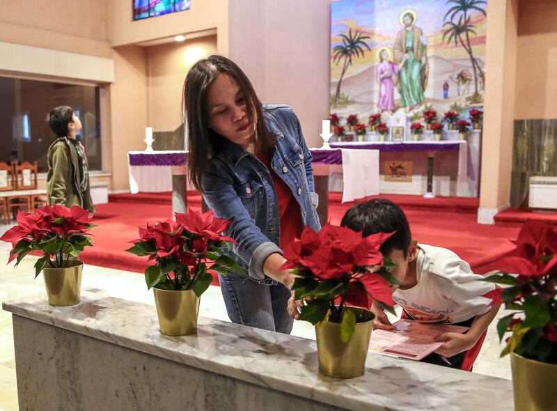 A mother and her son arrange some plants at St Joseph's Church
