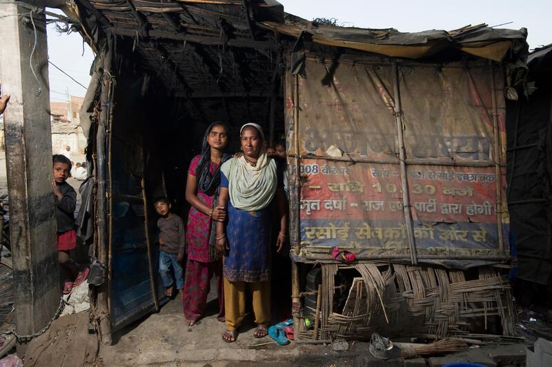 5th March 2012, JJ Colony, Bawana, Uttar Pradesh, Delhi, India. Ajija Khatoum (40) in the doorway of her makeshift home with her daughter Najima Bibi (25).  She was forced to move here 8 years ago with her family. ÒAll our neighbours slowly ran away from here,Ó said Mrs Khatoum. ÒSome simply abandoned the place but we stayed because we had nowhere else to go. We left a slum for a slum. This is worse. There is no peace because of the crime."
Bawana is an area 40 kilometers northwest of Delhi. 5,000 people (mostly migrants from other parts of India: domestic workers, rag pickers, rickshaw drivers, vegetable sellers and street sweepers) were forced to move here when their homes in a slum on the banks of the Yamuna river in Delhi were torn down in 2004. The relocation was a disaster. Far away from their jobs as day labourers or domestic workers, most lost their livelihood. Promises of schools, shops, and public transport never materialised. When they arrived there were no buildings, running water, sewage systems or electricity. With little work and no prospects it is little wonder that Bawana is now synonymous with drug and alcohol abuse. Bawana is the worst example of how resettlement efforts can go wrong. Crime and drugs use are rampant. The Delhi government is still sending evicted slum dwellers to Bawana. The population of the resettlement area, originally built for 10,000 people, now has ballooned to 60,000. 

PHOTOGRAPH BY AND COPYRIGHT OF SIMON DE TREY-WHITE

+ 91 98103 99809
+ 91 11 435 06980
+44 07966 405896
+44 1963 220 745
email: simon@simondetreywhite.com

