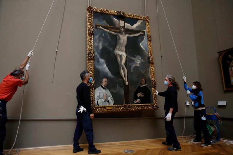 Workers lift a painting called 'Christ on the Cross Adored by Two Donors' by Spanish painter El Greco, as it returns from an exhibition at the Chicago Institute. AP