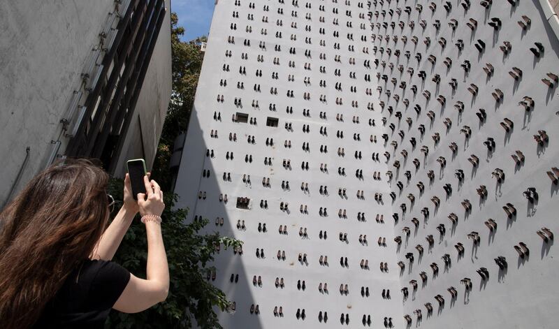 A woman takes a picture of a contemporary art installation by Turkish artist Vahit Tuna that aims to raise awareness on women killed by domestic violence, in Istanbul, Turkey.  EPA