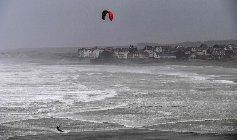 A kite surfer rides in the water during stormy weather off the Wissant's Bay, northern France as Storm Ciara sweeps across western Europe.  AFP