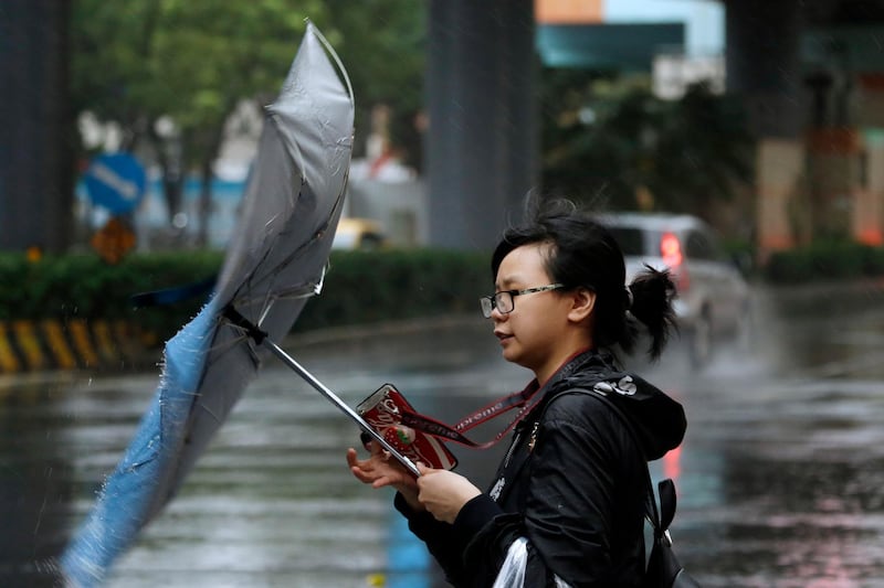 A woman struggles against gusts of wind generated by Typhoon Mitag in Taipei, Taiwan. Fast-moving Typhoon Mitag was bearing down on northern Taiwan on Monday, bringing high winds and heavy rain and forcing flight cancellations. AP Photo