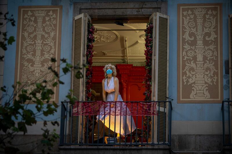 A mannequin wearing a face mask decorates a balcony in a shop in Barcelona, Spain. AP Photo