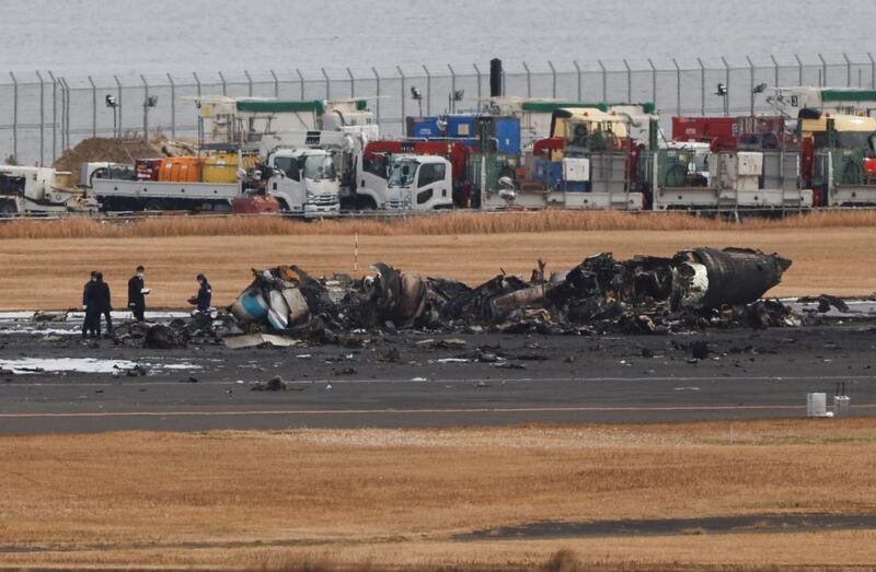 Investigators sift through the remains of a coastguard plane after a collision with Japan Airlines' Airbus A350 at Haneda International Airport in Tokyo. Reuters