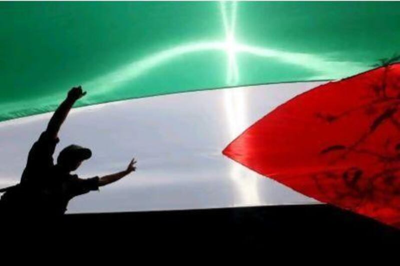 A Hamas security member walks under a large Palestinian flag on the 64th Nakba Day. MOHAMMED SABER / EPA