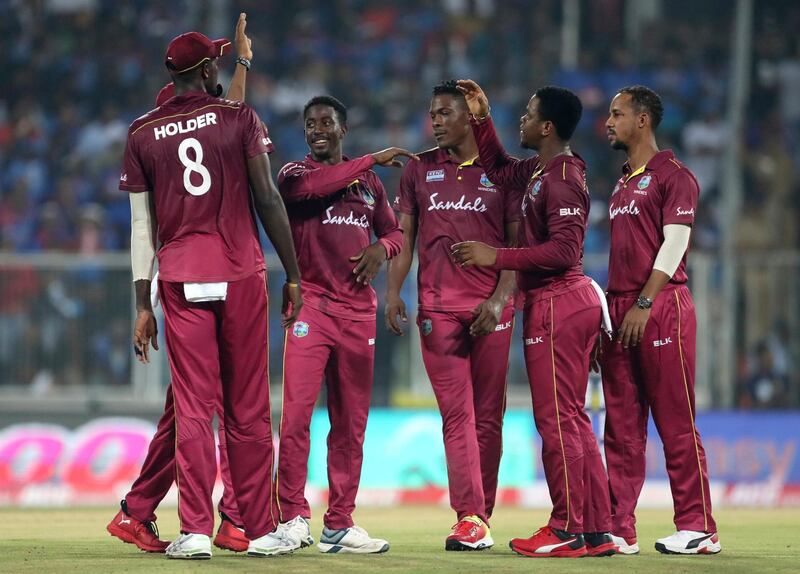 West Indies' Hayden Walsh, second left, celebrates with teammates after dismising Shivam Dube. AP