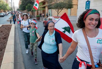 Lebanese protesters hold hands to form a human chain along the coast from north to south as a symbol of unity, during ongoing anti-government demonstrations in Lebanon's capital Beirut on October 27, 2019. / AFP / ANWAR AMRO
