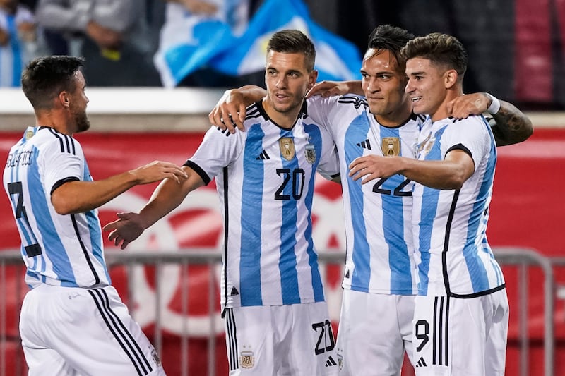 Julian Alvarez, right, celebrates with teammates after scoring Argentina's opening goal. AP