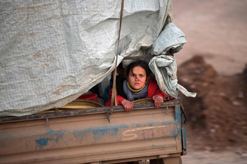 A displaced Syrian girl rides in the back of a truck on the way to Deir al-Ballut camp in Afrin's countryside along the border with Turkey.  AFP