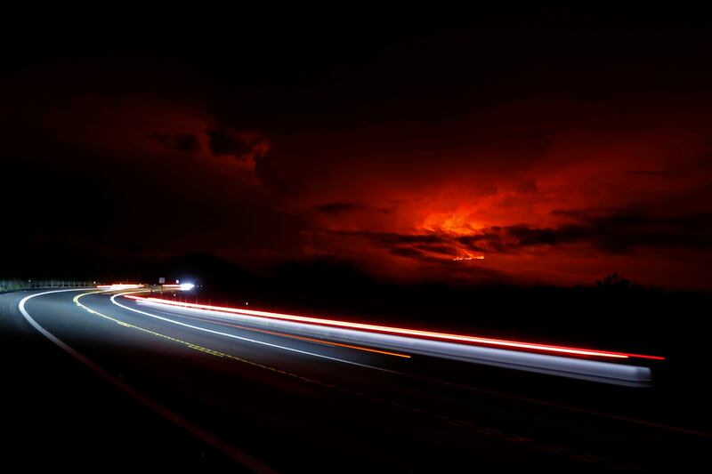 In this long camera exposure, cars drive down Saddle Road near Hilo, Hawaii, as Mauna Loa, the world's largest active volcano, erupts for the first time in 38 years in the distance. AP Photo

